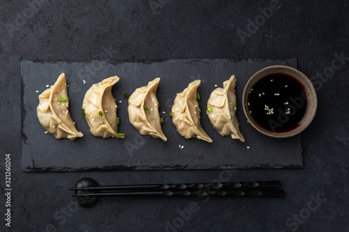 Traditional japaneese gyoza dumplings on black slate plate photo
