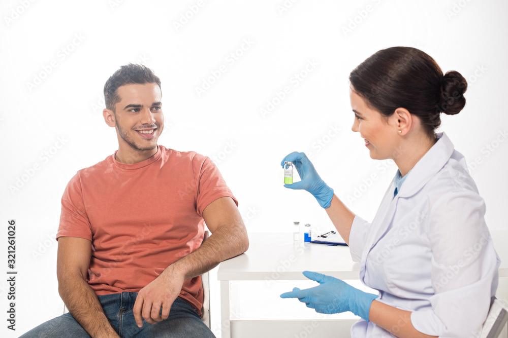 Smiling doctor showing vaccine to patient isolated on white Smiling doctor showing vaccine to patient isolated on white