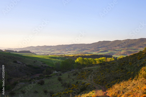 Fototapeta Naklejka Na Ścianę i Meble -  sunset in the mountains green yellow field