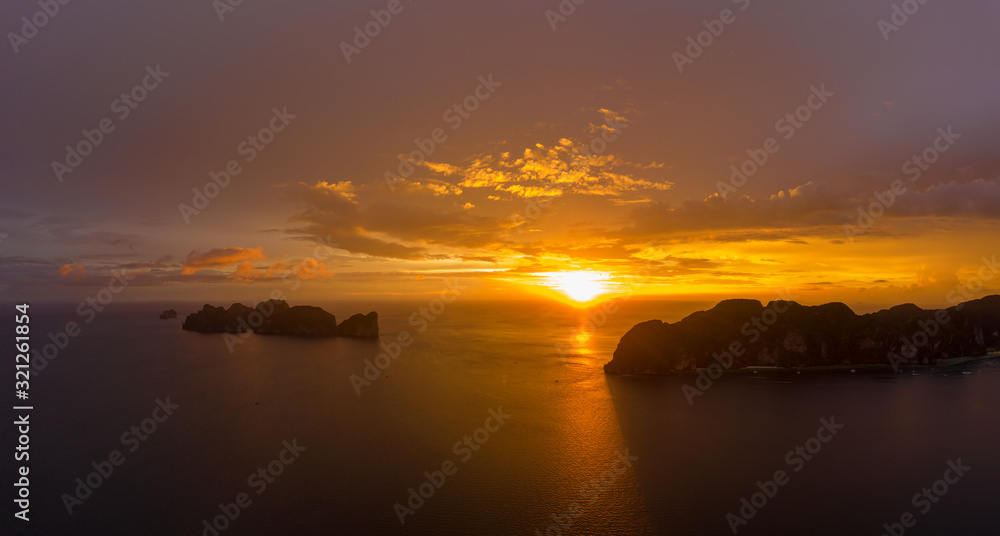 Aerial view of Phi Phi, Maya beach with blue turquoise seawater, mountain hills, and tropical green forest trees at sunset with Andaman sea  island in summer, Thailand in travel trip. Nature. Panorama