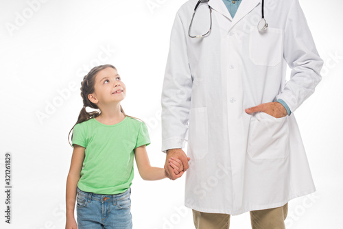 Smiling kid holding hand of pediatrician isolated on white