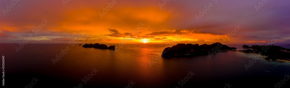 Aerial view of Phi Phi, Maya beach with blue turquoise seawater, mountain hills, and tropical green forest trees at sunset with Andaman sea  island in summer, Thailand in travel trip. Nature. Panorama