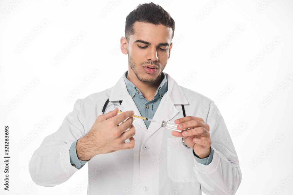 Handsome doctor with stethoscope picking up vaccine in syringe isolated on white Handsome doctor with stethoscope picking up vaccine in syringe isolated on white