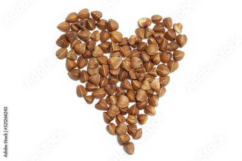Foto Healthy dried buckwheat grains with heart shape isolated white background