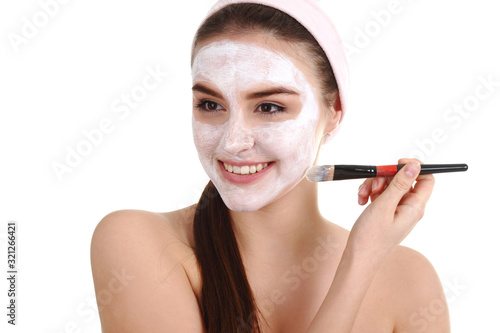 Young beautiful girl receiving pink facial mask in spa beauty salon - indoors photo