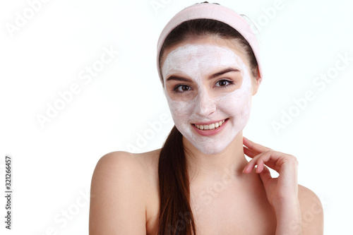 beautiful girl receiving pink facial mask in spa beauty salon - indoors photo