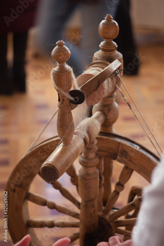A spinning wheel with yarn baskets and old chair