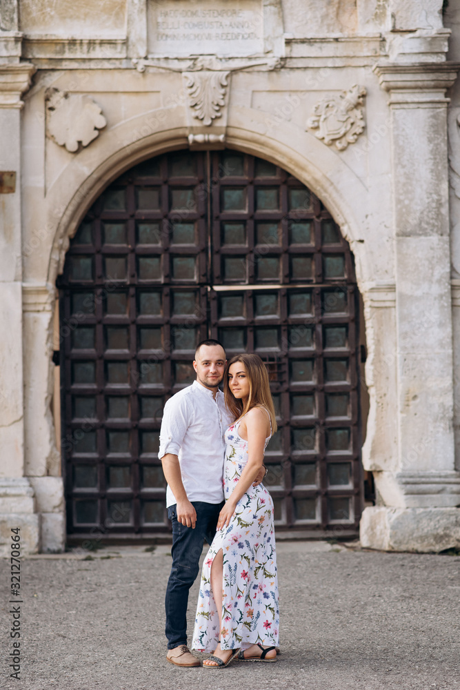 Young couple in love outside on old castle portal background