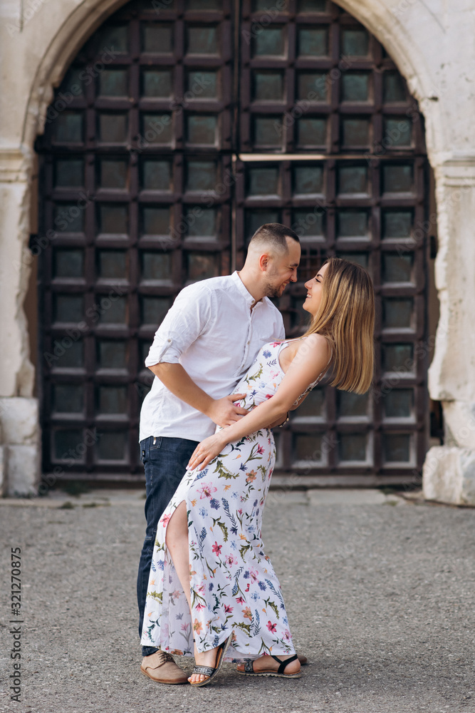 Young couple in love outside on old castle portal background