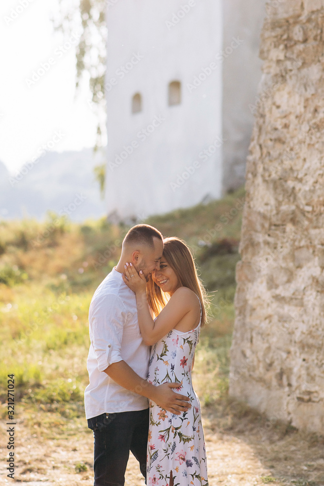 Lovely romantic couple outside during the summer and the sunset in backlight