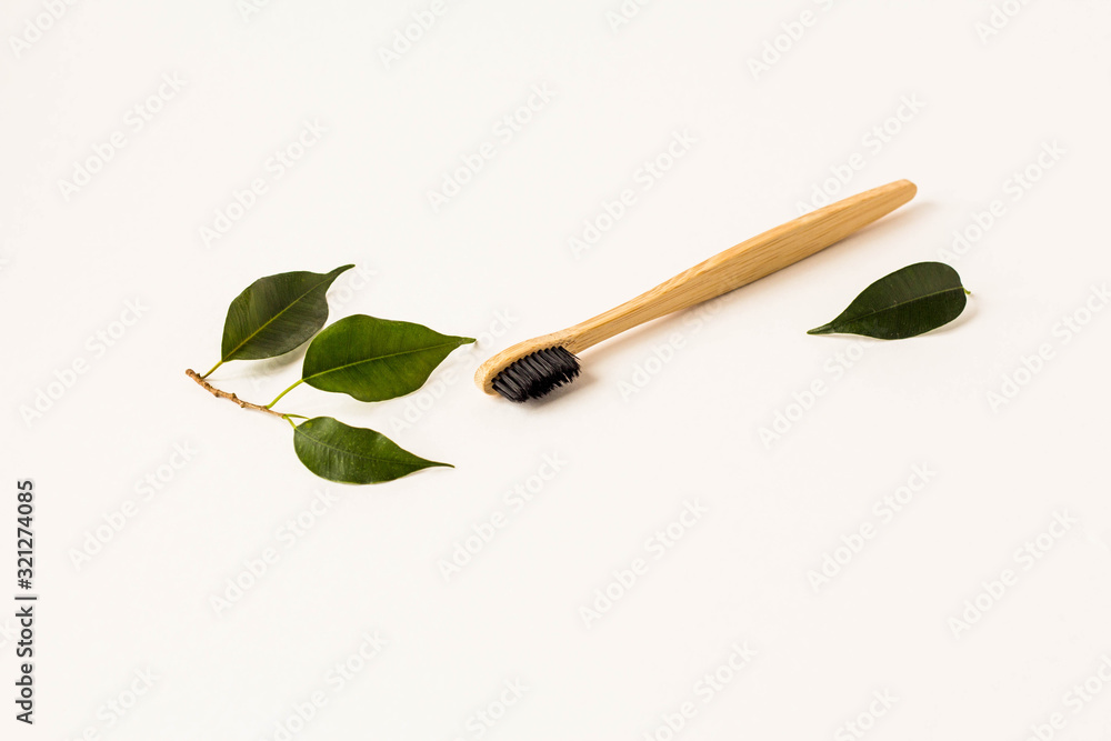 Eco friendly natural bamboo toothbrushes, shampoo bar, toothpaste in glass, wooden brush and konjaku sponge on white wood with green monstera leaves. Zero waste concept, plastic free Eco friendly natural bamboo toothbrushes, shampoo bar, toothpaste in glass, wooden brush and konjaku sponge on white wood with green monstera leaves. Zero waste concept, plastic free