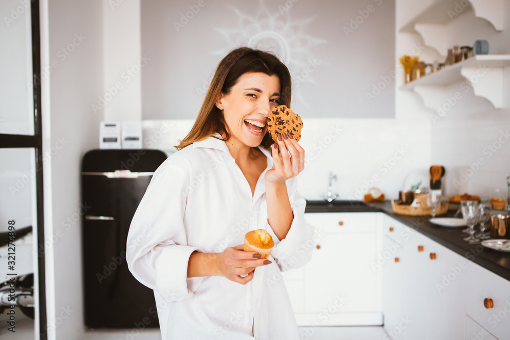 Young girl in white shirt stand on the kitchen and eat. Young girl in white shirt stand on the kitchen and eat.