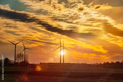 Stimmungsvolle Aufnahme mit Windrädern im Gegenlicht