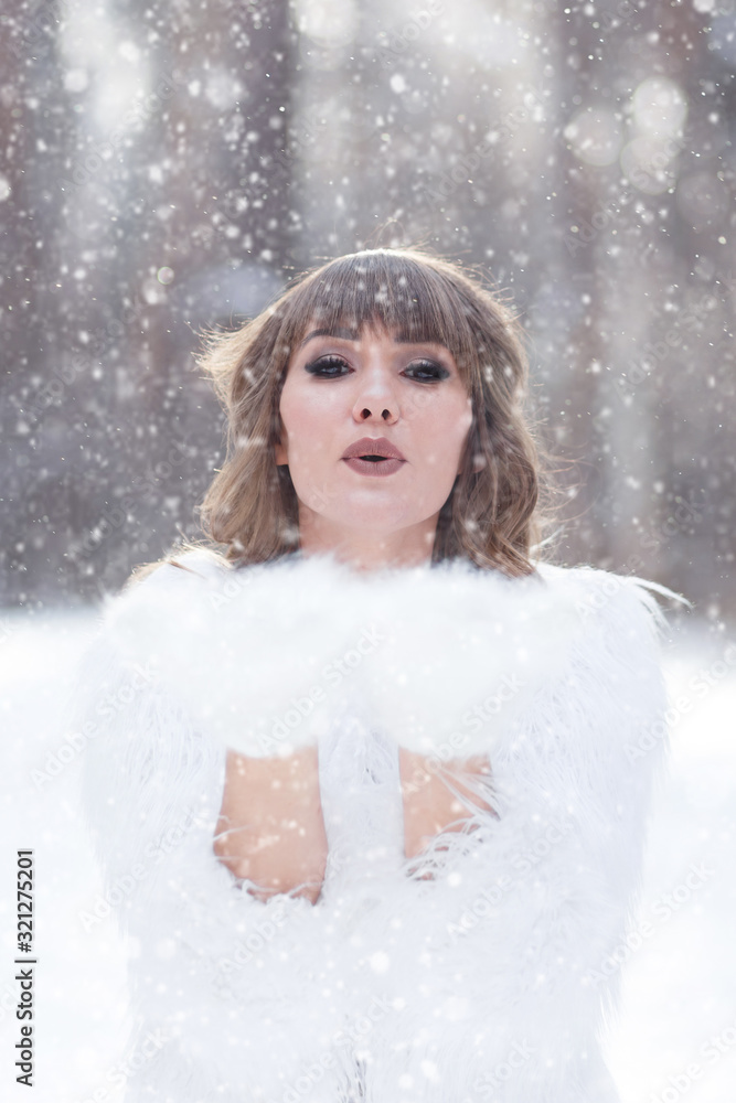 A beautiful pretty young girl with curly hair and a snow-white smile in a white warm coat is walking and fooling around in the winter forest against the background of snow and trees, enjoy A beautiful pretty young girl with curly hair and a snow-white smile in a white warm coat is walking and fooling around in the winter forest against the background of snow and trees, enjoy