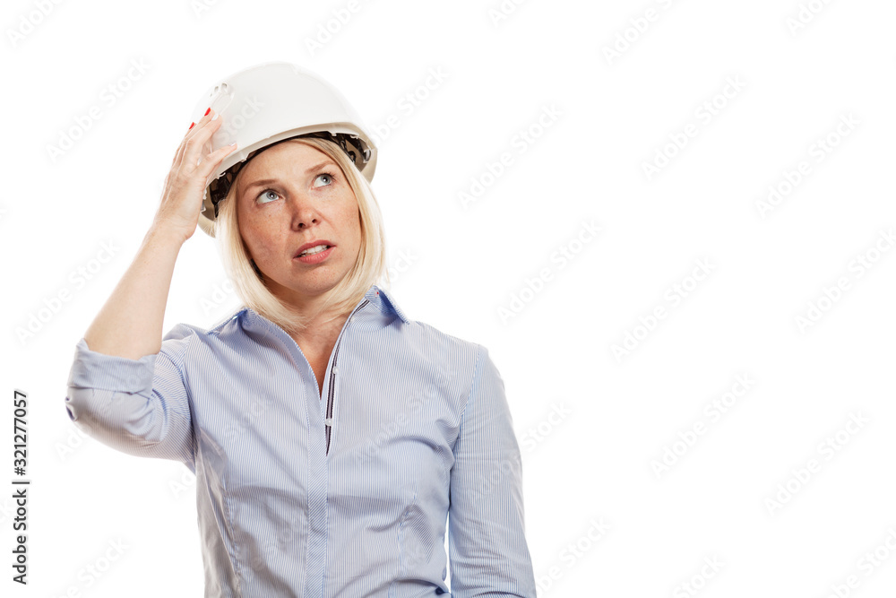 Young woman in a blue shirt and white construction helmet. Isolated over white background. Close-up. Young woman in a blue shirt and white construction helmet. Isolated over white background. Close-up.