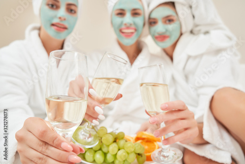 Sticker Female friends drinking wine in bed.