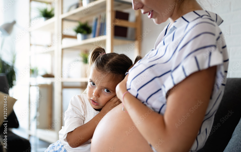 Obraz premium Beautiful pregnant woman with cute daughter. Pregnancy, family, love concept.
