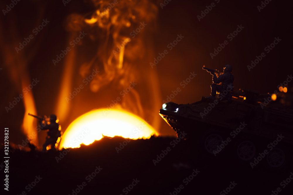 Battle scene with toy warriors and tank in smoke with sunset at background Battle scene with toy warriors and tank in smoke with sunset at background