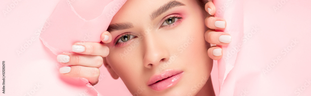 panoramic shot of beautiful young woman with pink makeup in torn paper, isolated on pink panoramic shot of beautiful young woman with pink makeup in torn paper, isolated on pink