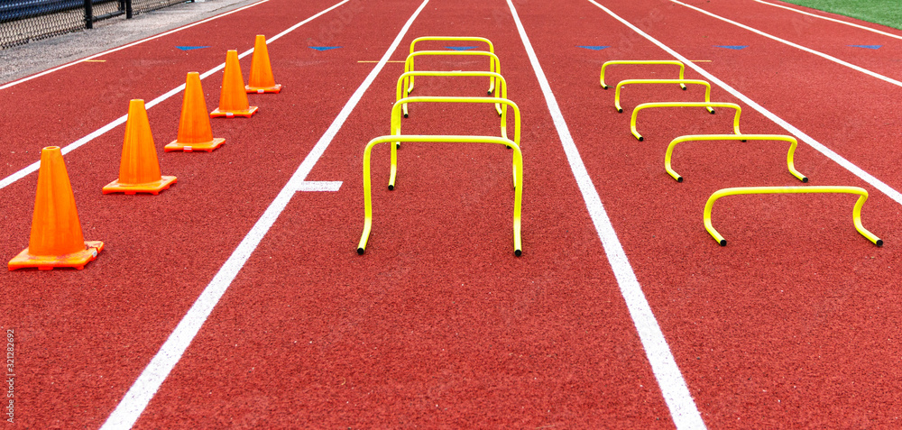 Orang cones and yellow mini hurdles set up on a track