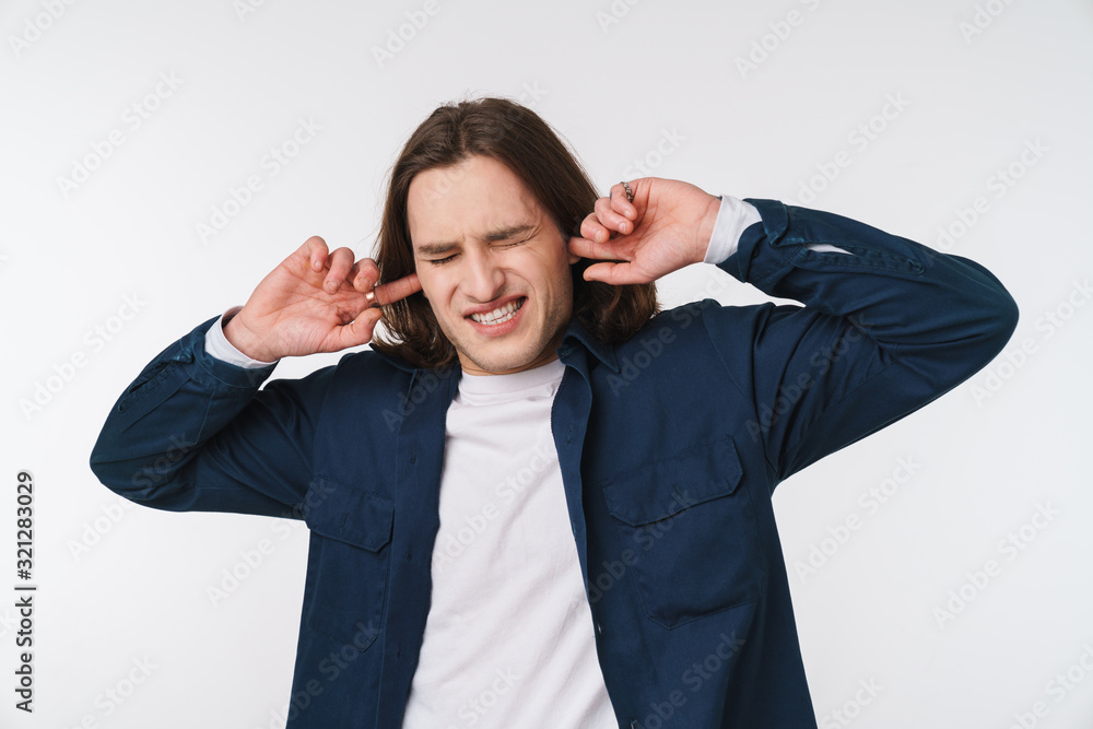 Image of stressed caucasian man looking upward and plugging his ears Image of stressed caucasian man looking upward and plugging his ears