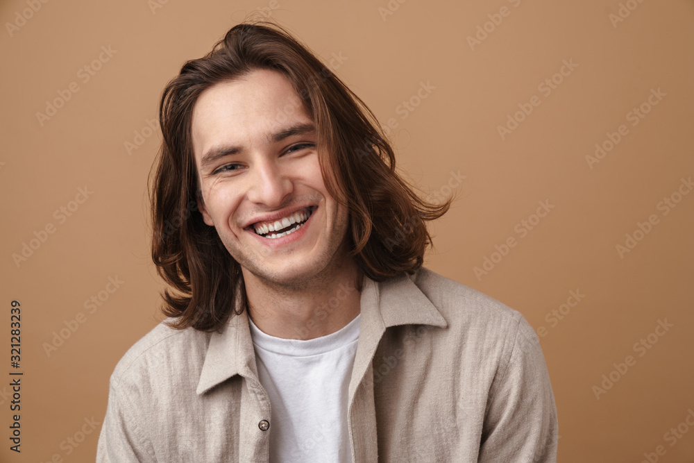 Image of joyful young man laughing and looking at camera Image of joyful young man laughing and looking at camera