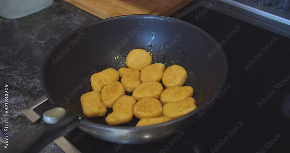 fried chicken nuggets meat are being cooked deep fried in a hot boiling oil pan fried chicken nuggets meat are being cooked deep fried in a hot boiling oil pan