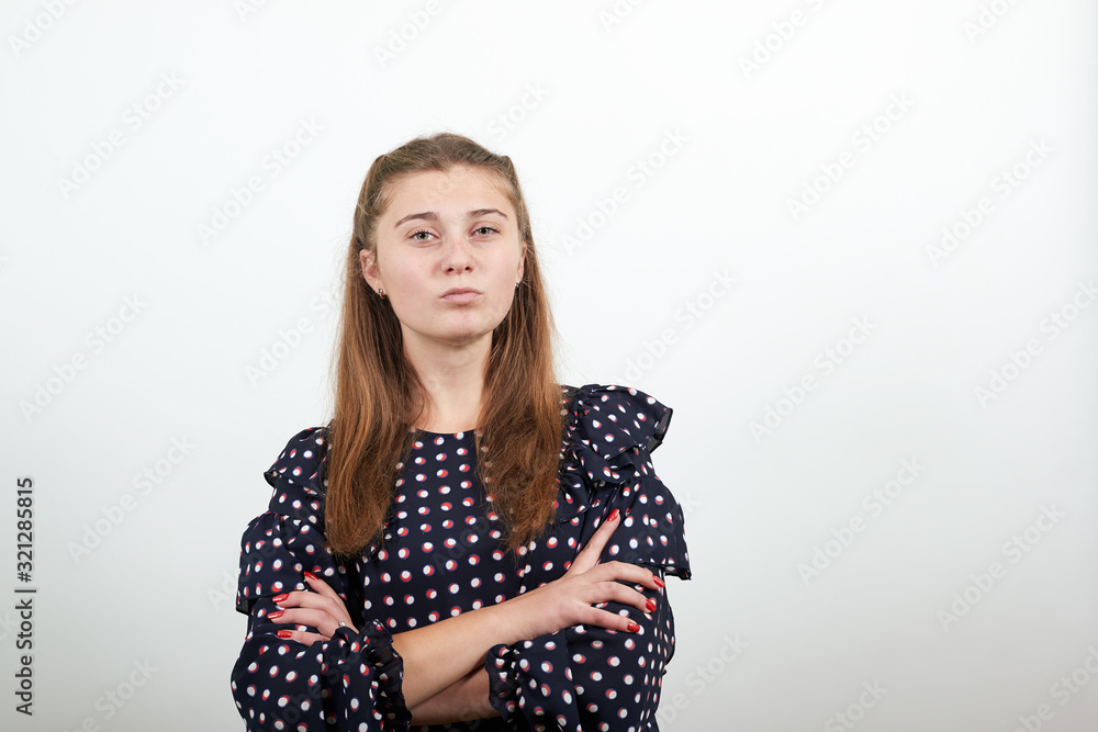 Fair-haired beautiful girl in a black dress with white circles with serious stylish look clasped her hands Fair-haired beautiful girl in a black dress with white circles with serious stylish look clasped her hands