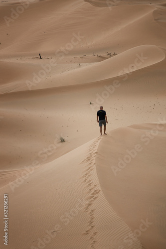 Lonely Man stands in  desert dune  Abu Dhabi.