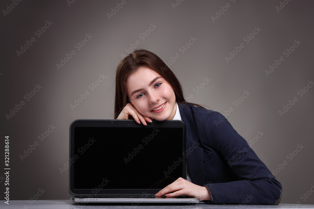 Pretty teen girl sitting at table with laptop.Studying Pretty teen girl sitting at table with laptop.Studying