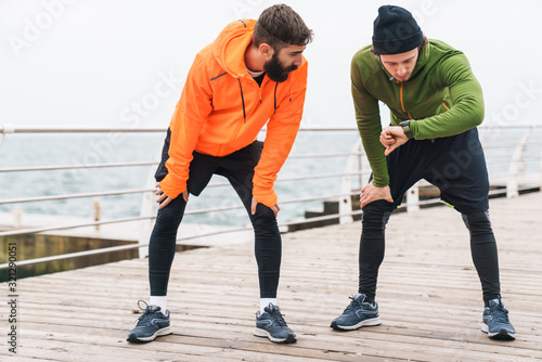 Two motivated young sportsmen exercising outdoors © Drobot Dean