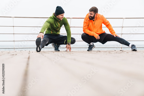 Two motivated young sportsmen exercising outdoors