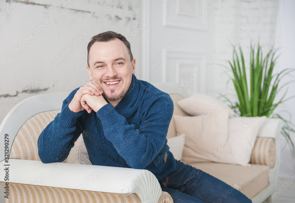 Handsome man smile sitting on coach at home Handsome man smile sitting on coach at home