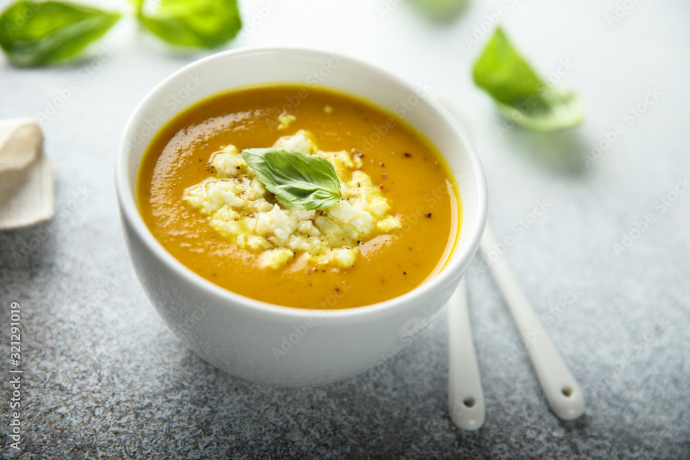Homemade carrot pumpkin soup with cheese and basil Homemade carrot pumpkin soup with cheese and basil
