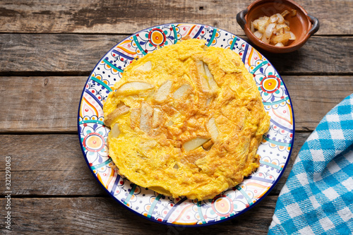 Spanish scrambled eggs with potatoes called tortilla or tapa on wooden background