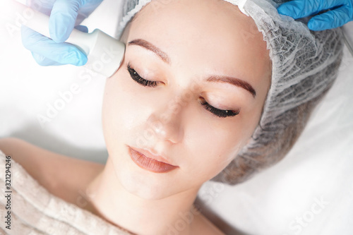 Microcurrent therapy for facial care. Cosmetologist doing face rejuvenation treatment.