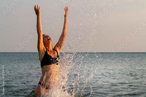 woman splashing in the seaat dusk photo