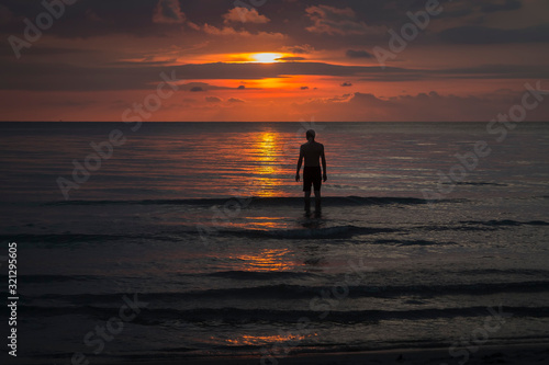standing in the asian sea at sunset