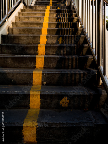 The footbridge for cross the road in Thailand with yellow mark and arrow direction.