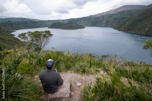 Viewpoint with man sit in front of Lagoon Cuicocha, Ecuador