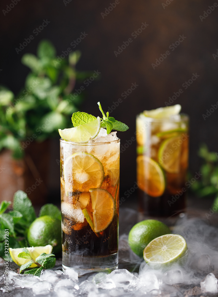 Fototapeta premium Cuba Libre with brown rum, cola, mint and lime. Cuba Libre or long island iced tea cocktail with strong drinks