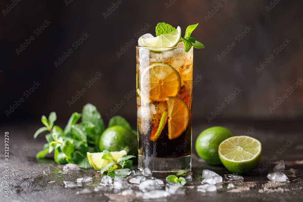 Fototapeta premium Cuba Libre with brown rum, cola, mint and lime. Cuba Libre or long island iced tea cocktail with strong drinks