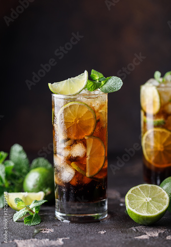 Cuba Libre with brown rum, cola, mint and lime. Cuba Libre or long island iced tea cocktail with strong drinks