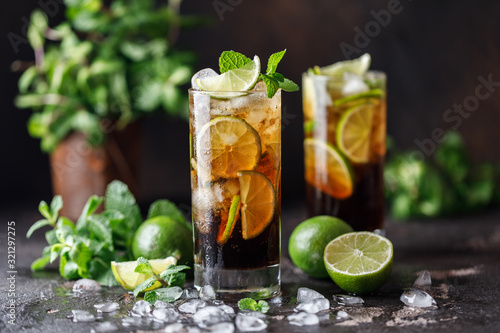 Cuba Libre with brown rum, cola, mint and lime. Cuba Libre or long island iced tea cocktail with strong drinks