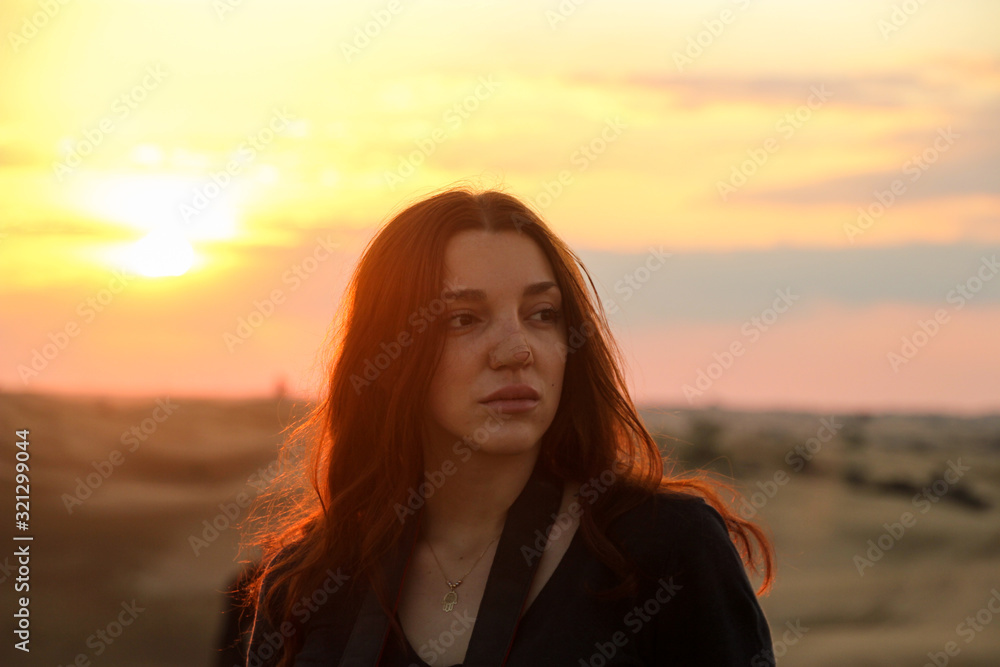 Redhead woman on the desert with sunset light Redhead woman on the desert with sunset light