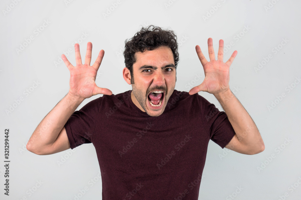 Man giving a fright with open hands. Brown, handsome man with mustache and purple t-shirt. Funny portrait. Gray background. Man giving a fright with open hands. Brown, handsome man with mustache and purple t-shirt. Funny portrait. Gray background.