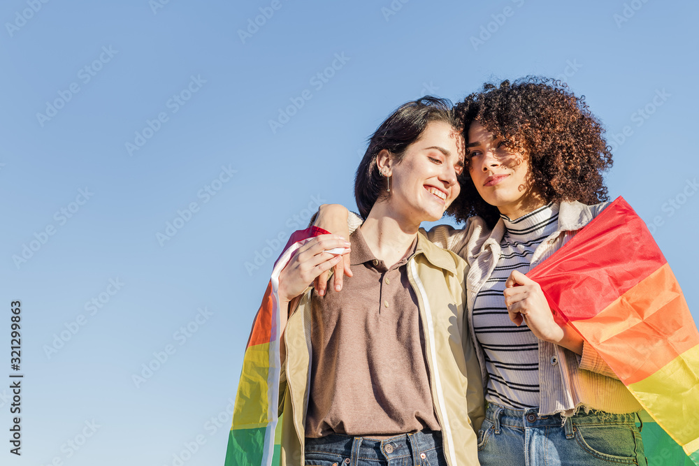 gay couple of women embracing with a rainbow flag gay couple of women embracing with a rainbow flag