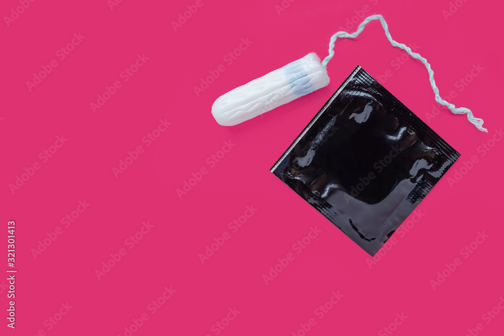 women intimate hygiene products - sanitary pads and tampon on pink background. Sex during menstruation, condom, tampon, pad. protection during sex. ovulation and gynecology. Intimate life
