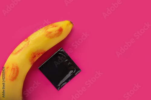 sex, banana kisses and a condom. protected sexual intercourse. banana on a pink background. erotica with a banana. banana and penis. safe sex