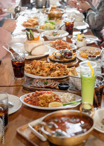 Various kind of gourmet food and drink with family eating on wooden table